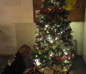 A decorated Christmas tree at Macca with presents underneath on Christmas Eve