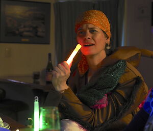 Danielle in costume using the glow stick as a microphone