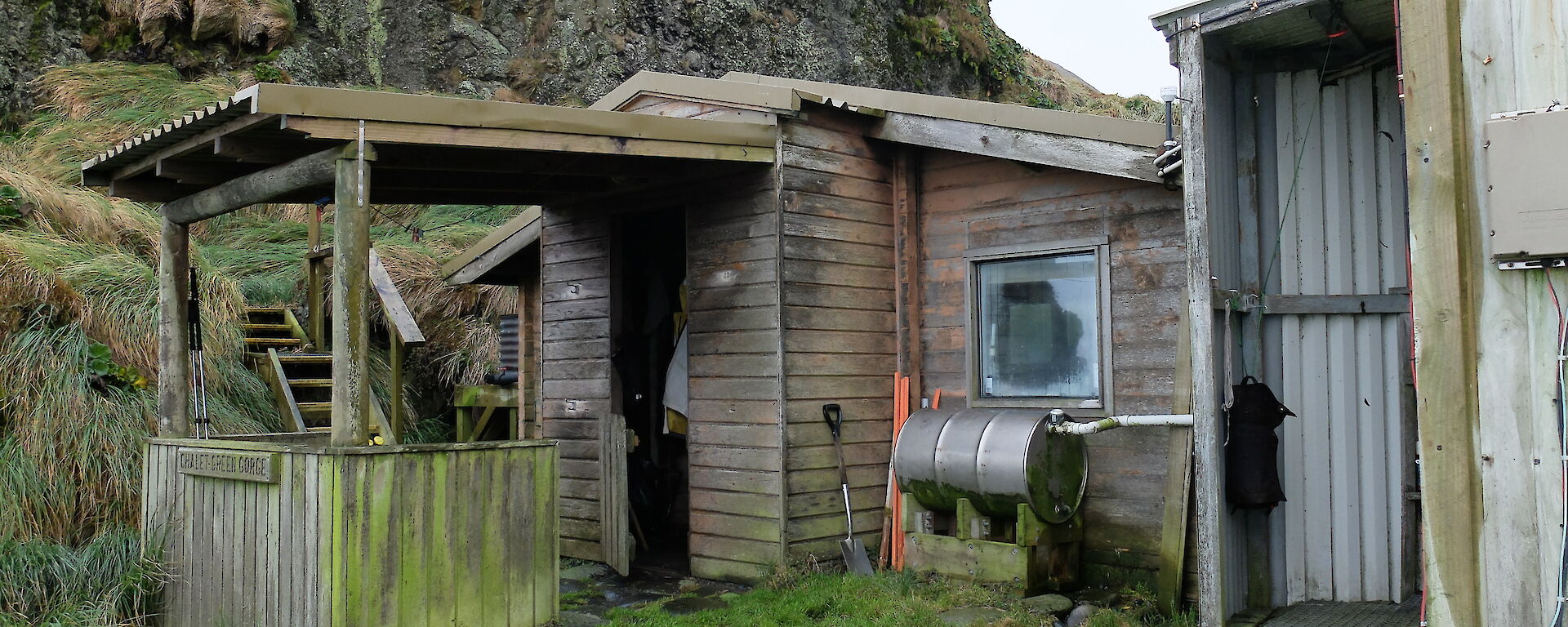 Green Gorge hut showing a tank outside the hut with pipe feed outside the hut