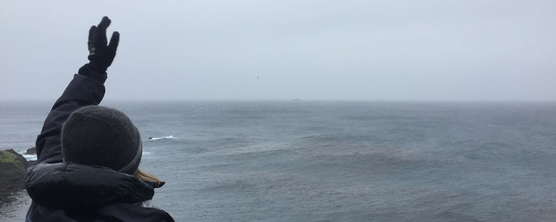 Ali Dean waving to the ship from the Ham Shack on Macquarie Island