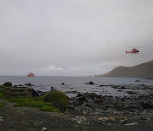 A helicopter coming in to land at Macquarie Island to begin the annual resupply and handover