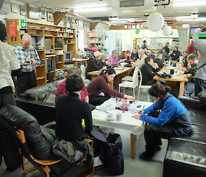 A shipload of visitors in the Macquarie Island Mess, frantically writing postcards home to loved ones