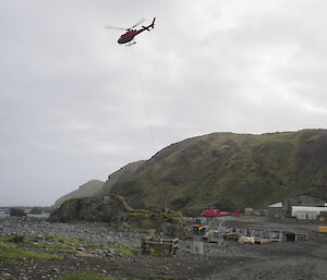 One of the resupply helicopters carrying a container full of food out to the field huts scattered around Macquarie Island