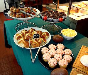 Trays of Easter treats are on display including hot cross buns, cupcakes and chocolate