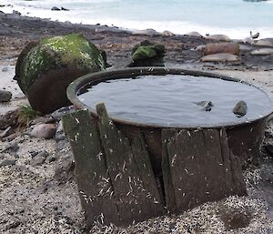 rusted metal pots are on a beach