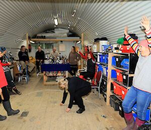 a group of people are playing a game of two up in a shed