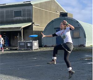 a woman jumps in the air to catch a frisbee