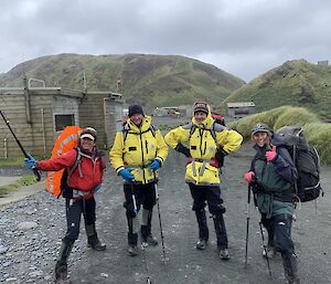 four people wear hiking gear ready to go on a hike