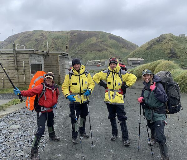 four people wear hiking gear ready to go on a hike