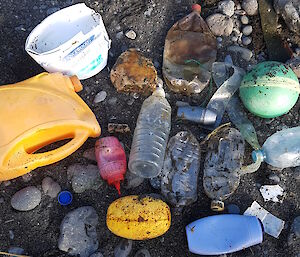 A pile of dirty plastic bottles and coloured plastic tubs, containers and a red sauce bottle