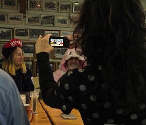 a woman holding a camera with her back to the camera is filming two characters in rabbit and Ranger costumes