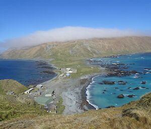 a long white cloud hangs over the top of the island plateau