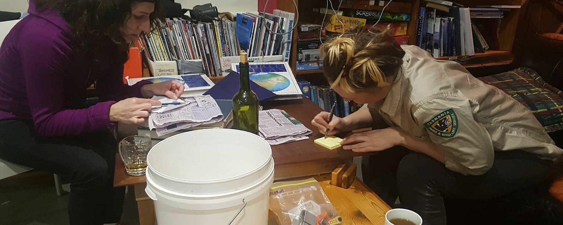 Two women are concentrating on a note
