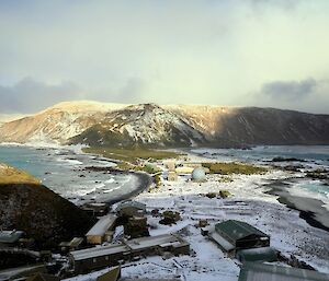 A view of the Macquarie island Research station dusted in snow with the plateau in the distance