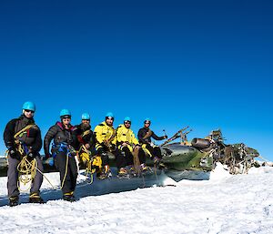 Expeditioners sitting on wing of aircraft remains