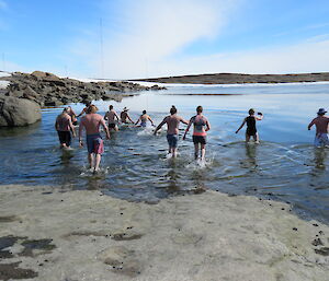 A group of swimmers enter the water