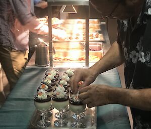 Chef putting the finishing touches on dessert in the bain marie.