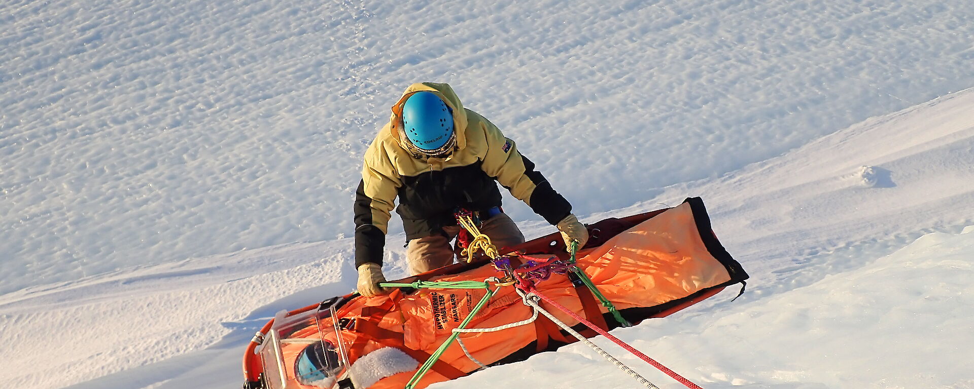 Mawson Search and Rescue team member carrying out a stretcher haul at ‘Endwave’ in the Framnes Mountains.