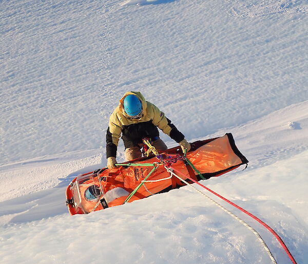 Mawson Search and Rescue team member carrying out a stretcher haul at ‘Endwave’ in the Framnes Mountains.