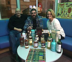 Mawson expeditioners Geoff, Chris, and Jan enjoy a whisky tasting night.
