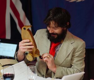 Mawson Plumber Tom Carew receiving a hand-crafted wooden penguin Midwinter gift.