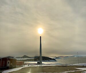 The sun above, and halo around, the disused turbine tower, appearing almost as a candle — Mawson.