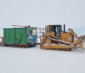 Rumdoodle Hut being towed by a D-15 Dozer down the GWAM ice road to Mawson Station.