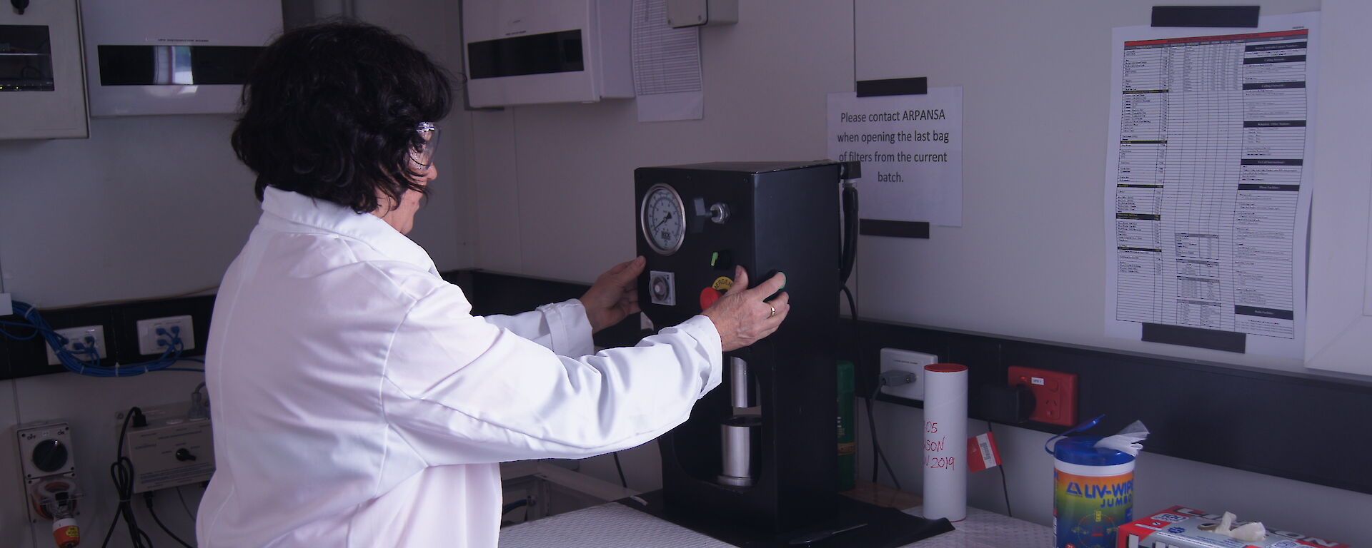 Sandra Sdraulig operating the press to compact the filter sample to a disc for analysis.