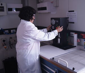 Sandra Sdraulig operating the press to compact the filter sample to a disc for analysis.