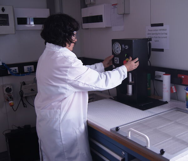 Sandra Sdraulig operating the press to compact the filter sample to a disc for analysis.