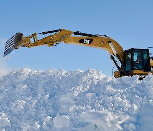 Digger scoops snow away