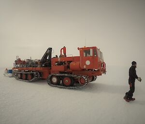 A large red tracked vehicle and a man on the ice