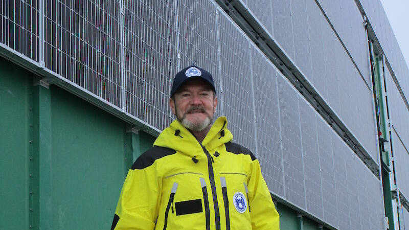 Australian Antarctic Division Director Kim Ellis beside a solar panel installation at Casey research station.
