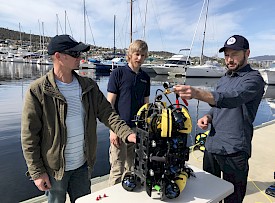 Dr Jonny Stark (left), SOSub Director Kelsey Treloar, and Dr Glenn Johnstone, with the ROV, at a wharf in Hobart.