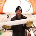 Dr Mark Curran holds an ice core inside a drill tent in Antarctica.