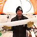Dr Mark Curran holds an ice core inside a drill tent in Antarctica