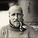 Bob Bage outside Mawson’s Huts smoking a pipe.