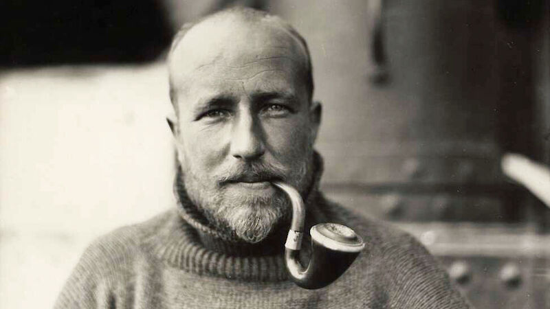 Bob Bage outside Mawson’s Huts smoking a pipe.