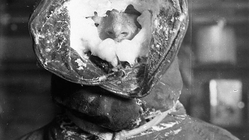 Antarctic expeditioner from 1914 with ice-encrusted hood around his face.