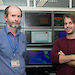 Two men in front of computer screens set up to mimic the Aurora Australis science control room and deliver ‘data in real time’.