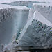 An iceberg calving off an ice shelf.