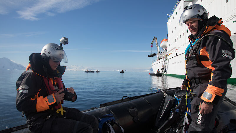 Australian Antarctic Division marine mammal scientists in a small boat, tagging blue whales.