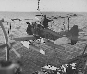 Eric Douglas (left) and Stuart Campbell swing the De Havilland Gipsy Moth over the side of Discovery during BANZARE (1929).