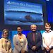 Four people posing before a screen displaying title ‘The Antarctica Experience'.