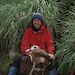 Dr Patricia Selkirk sitting beside tussock grass on Macquarie Island.