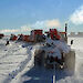 A train of tractors pulling fuel containers.