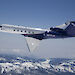 A Gulfstream V aircraft flying over mountains.