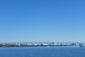 Rocks exposed in the shallow waters near Davis station, with Iceberg Alley behind.