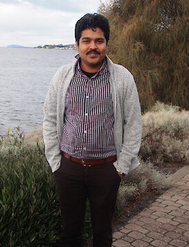 Dr Bishakhdatta Gayen standing beside the Derwent River in Hobart.