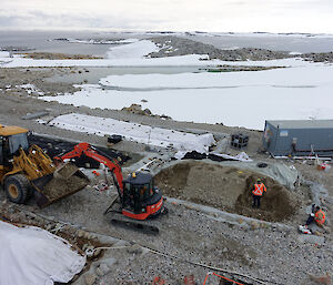 A digger removes soil from a biopile.